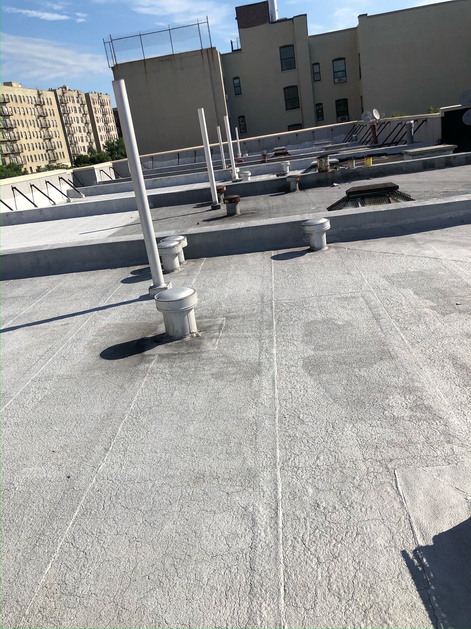 Coated flat roof of a residential building showing protective waterproof layer.