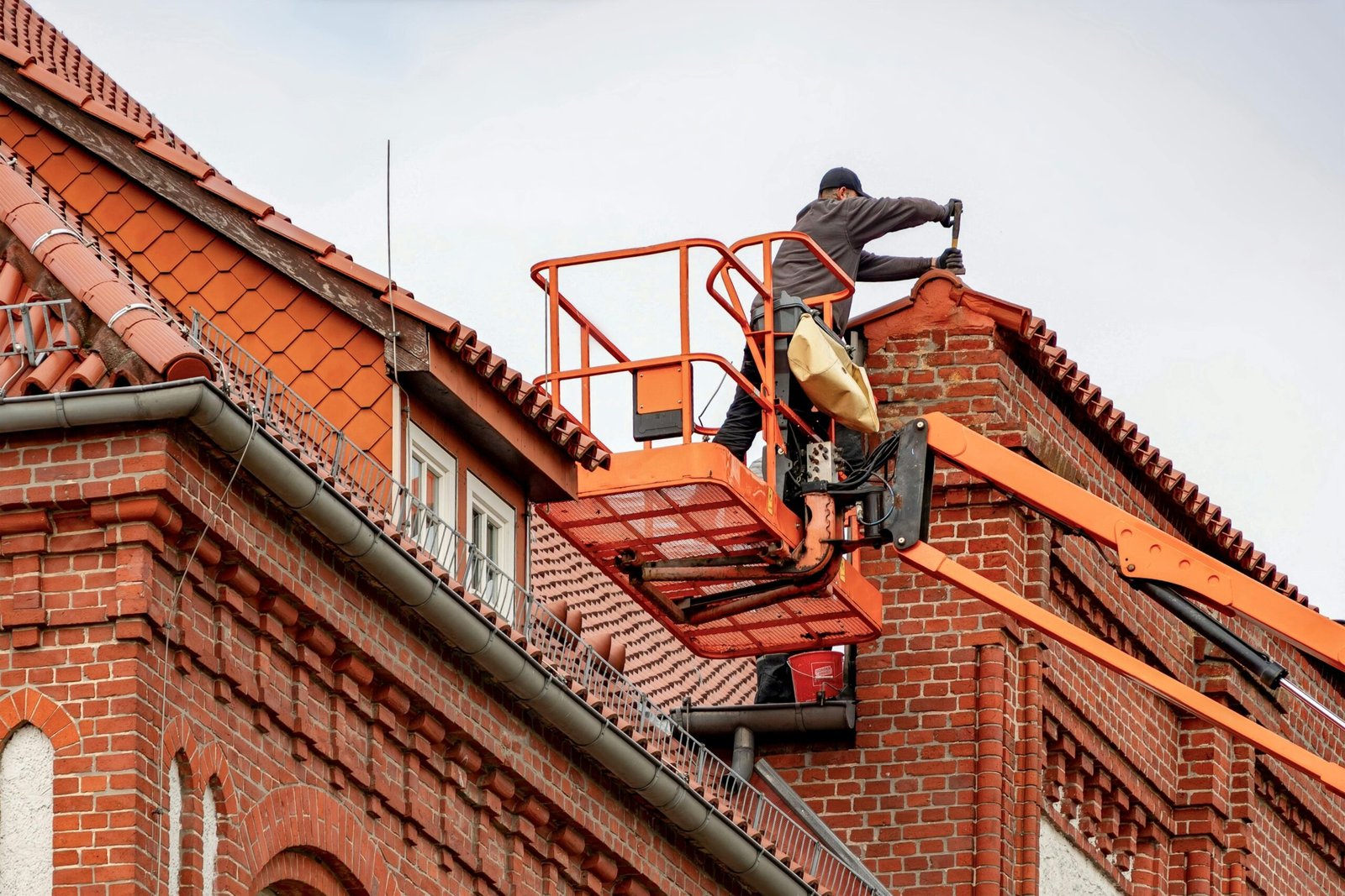 Roofer inspecting a residential roof to identify leaks and damaged shingles.